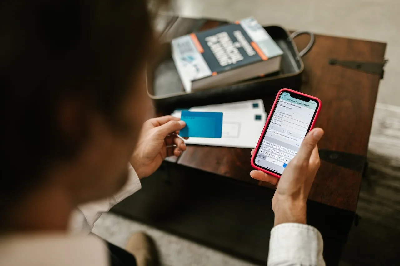 man checking out an online order on his phone with a credit card