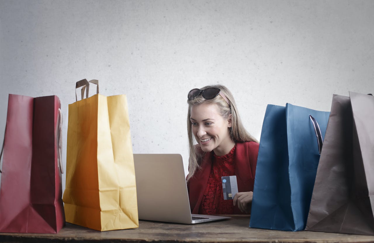 woman shopping online among paper bags